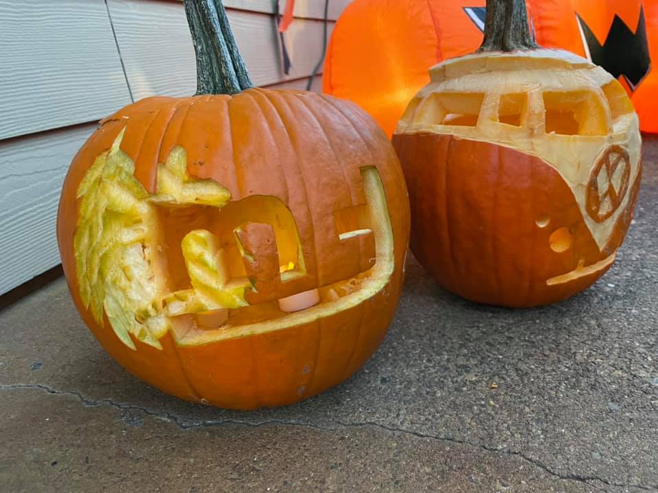 Two carved pumpkins sit outside of clubhouse
