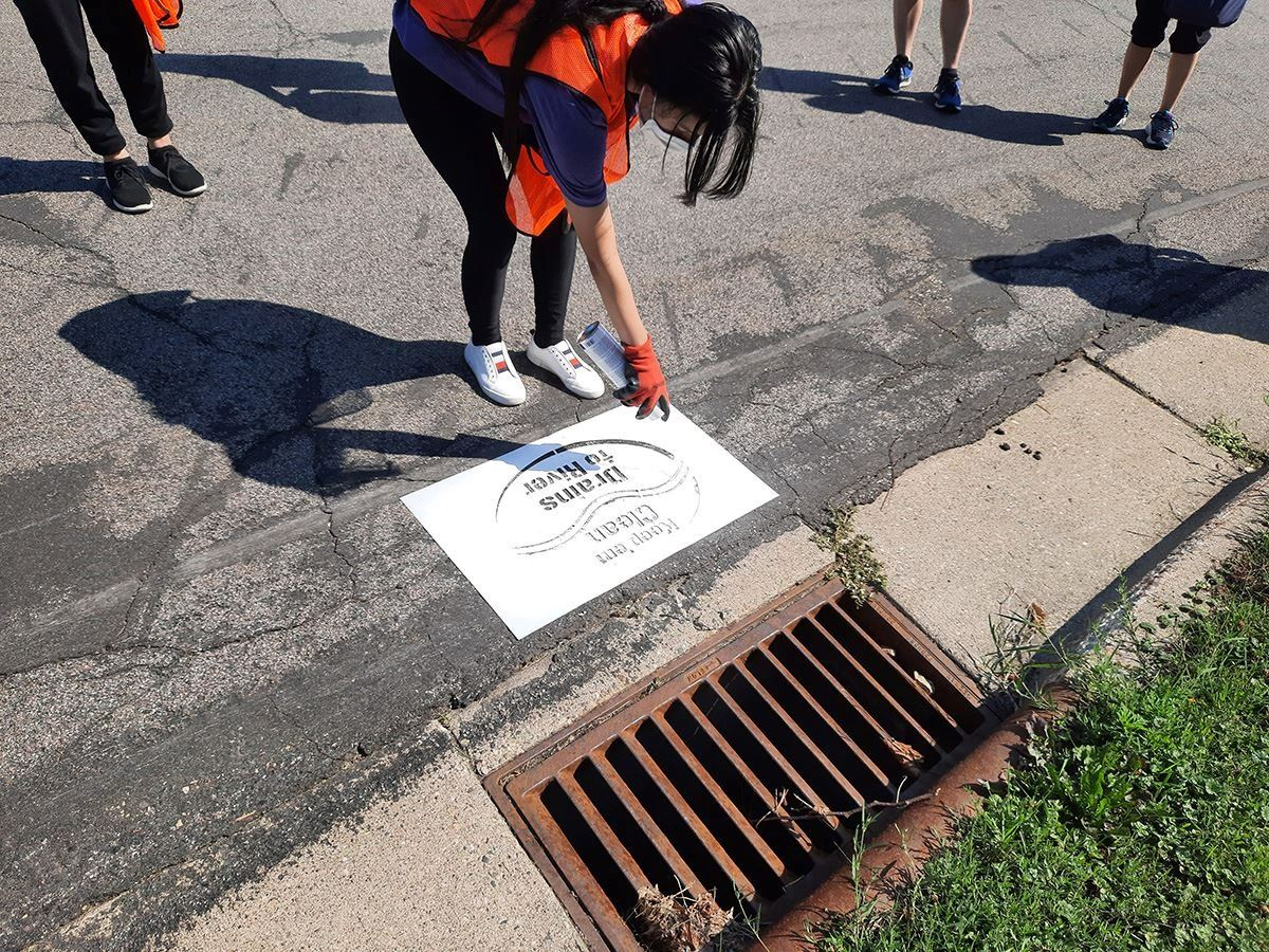 Volunteer stenciling storm drain.